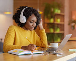 Hình ảnh về Person studying online on laptop with headphones