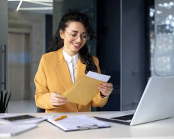 Hình ảnh về Person working on computer and holding certificate